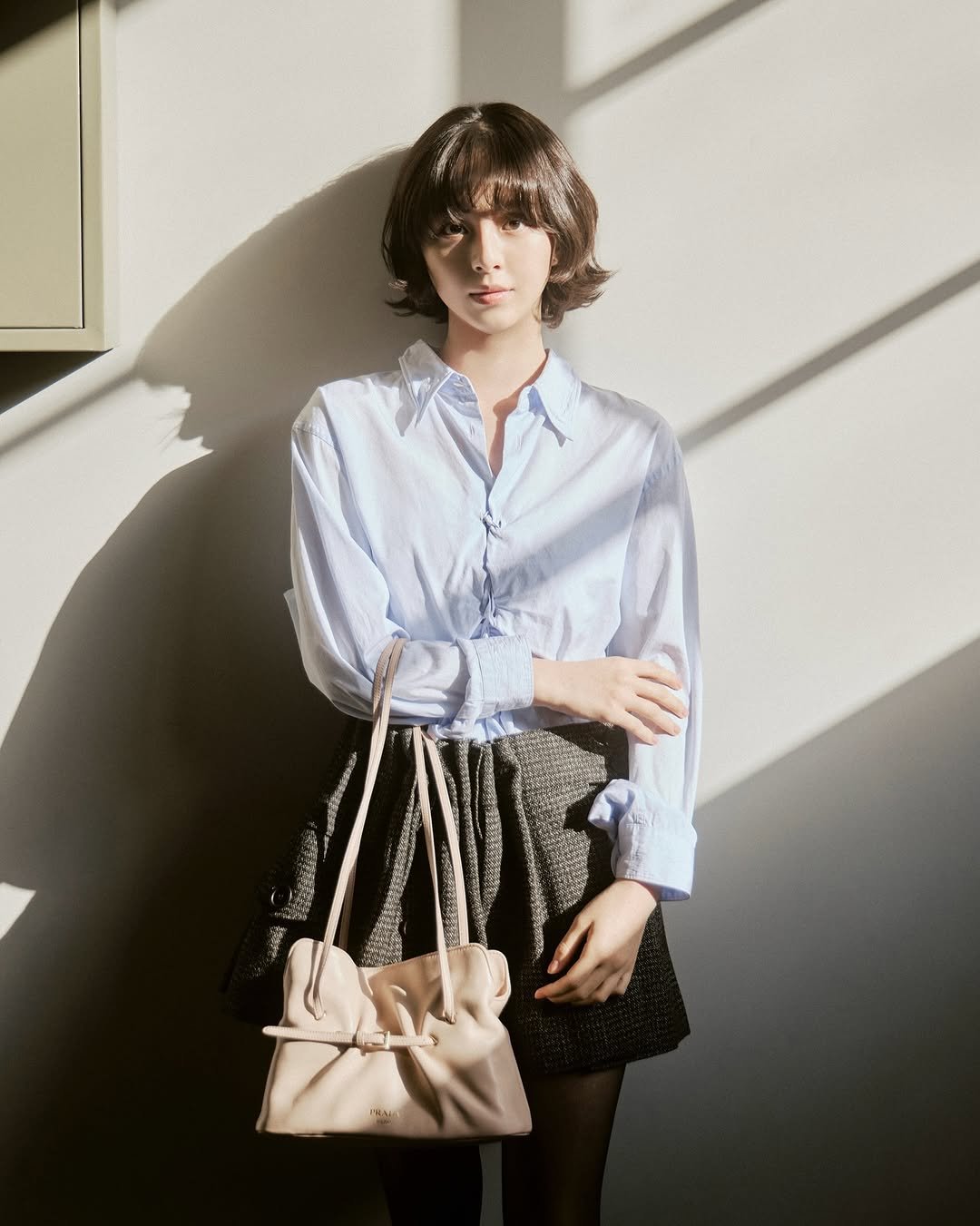 Photo shared by 박지후 on October 23, 2025 tagging @prada. May be an image of saddle-stitched leather, purse and text.