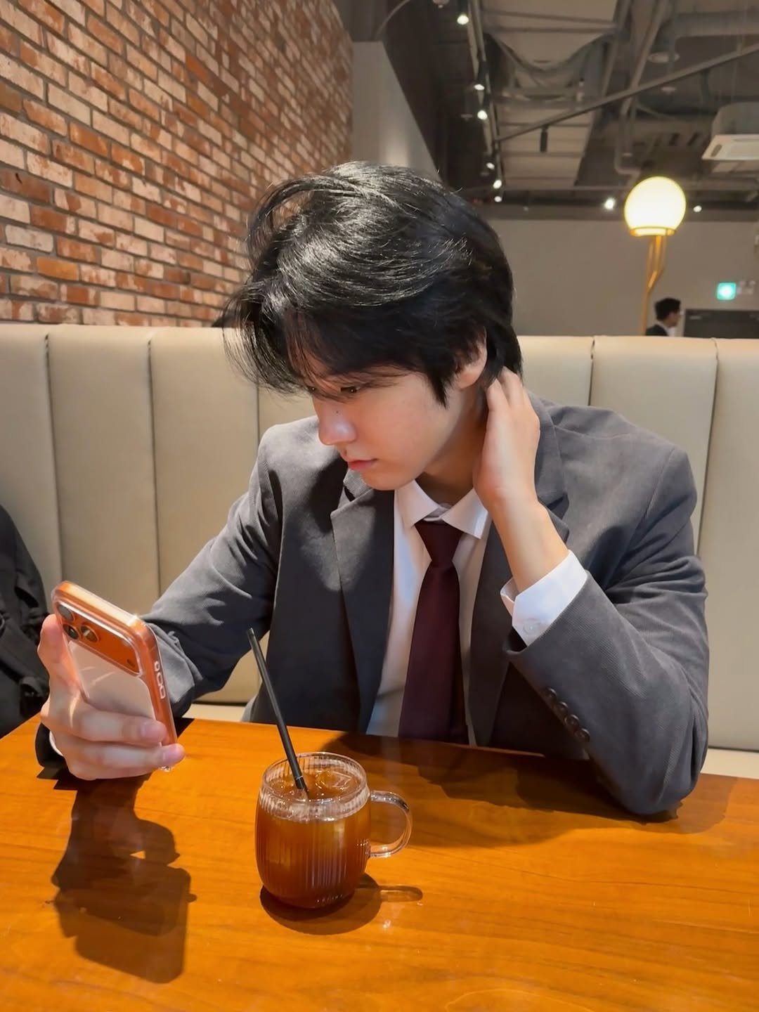 Photo by 유도열 on December 18, 2025. May be an image of phone, drink, suit, blazer and text.