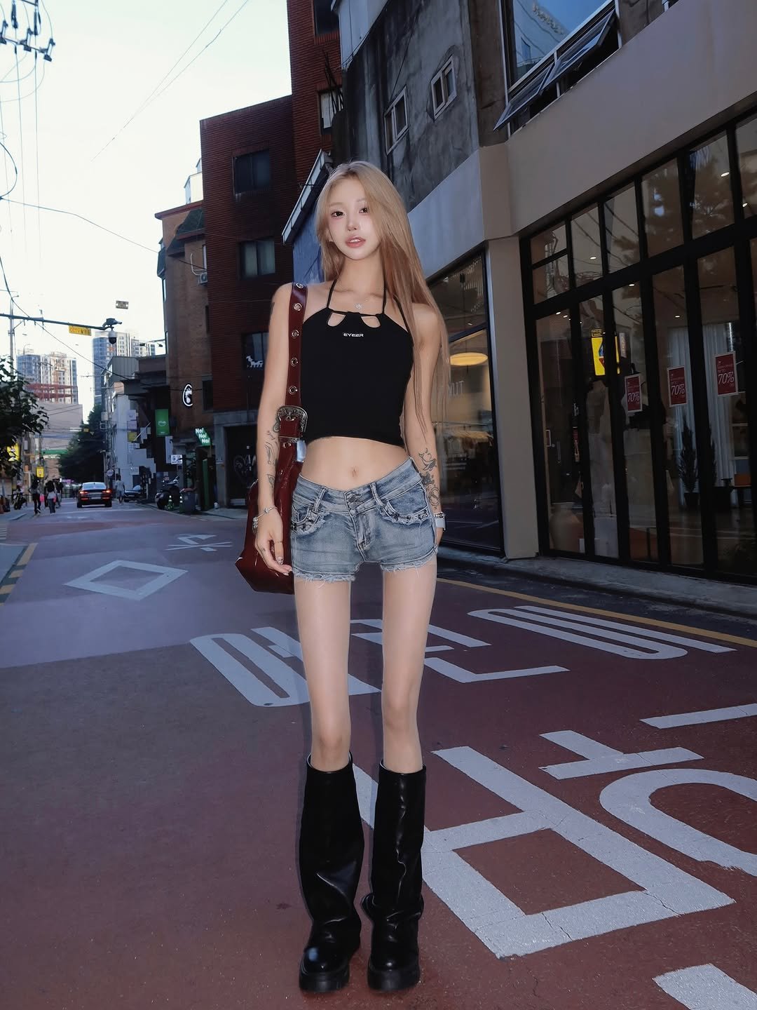 Photo shared by ָ 「 준희 」 on August 10, 2025 tagging @eyeer.official. May be an image of 3 people, blonde hair, miniskirt, boots, shorts, road, street and text.