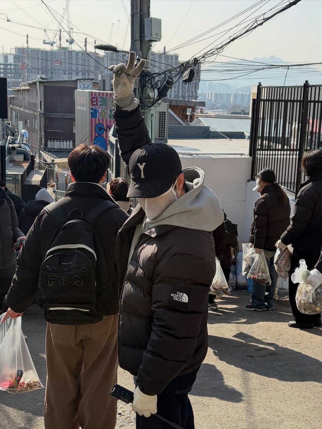 Photo by 청소하는사람 on February 07, 2026. May be an image of one or more people, people standing, duffle coat, suspension bridge and text.