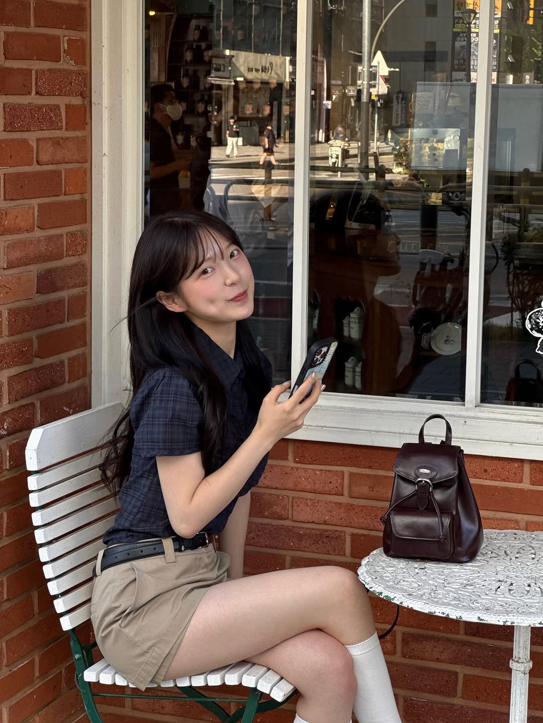 Photo by 유수현 on July 11, 2025. May be an image of 4 people, phone, shorts, miniskirt, cornflower, brick wall and text.