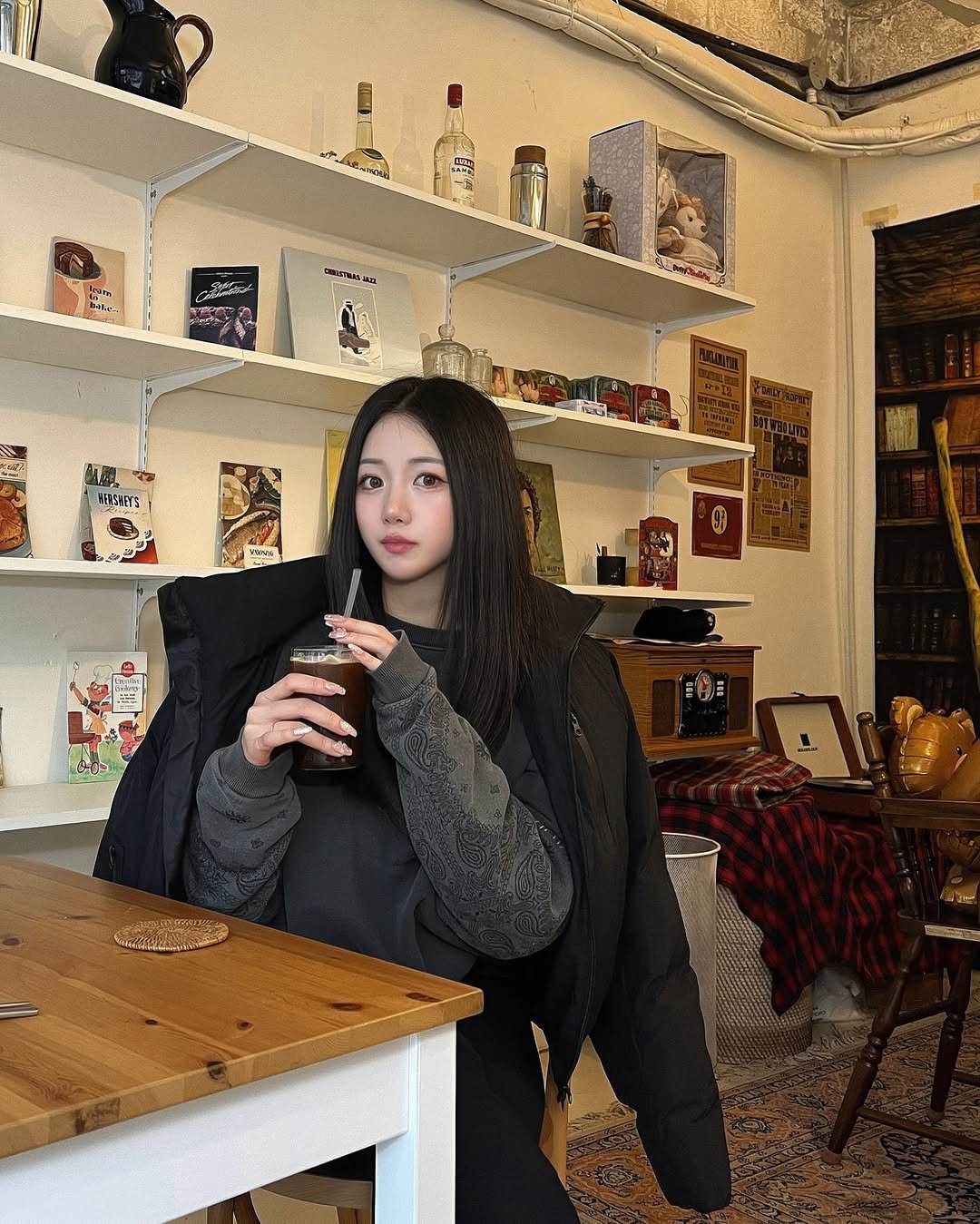 Photo shared by 지오 on November 17, 2025 tagging @decoroso_official, and @twospc.shoe. May be an image of duffle coat, cup, tea, turtleneck, cornflower and text.