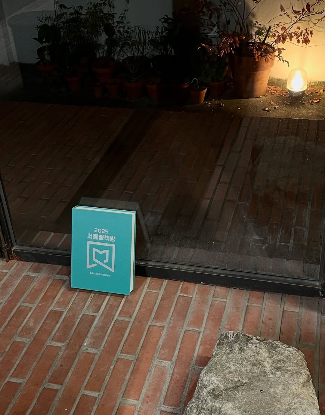 Photo shared by 인공위성 on August 15, 2025 tagging @seoulbookshops. May be an image of welcome mat, box, cornflower, door and text.