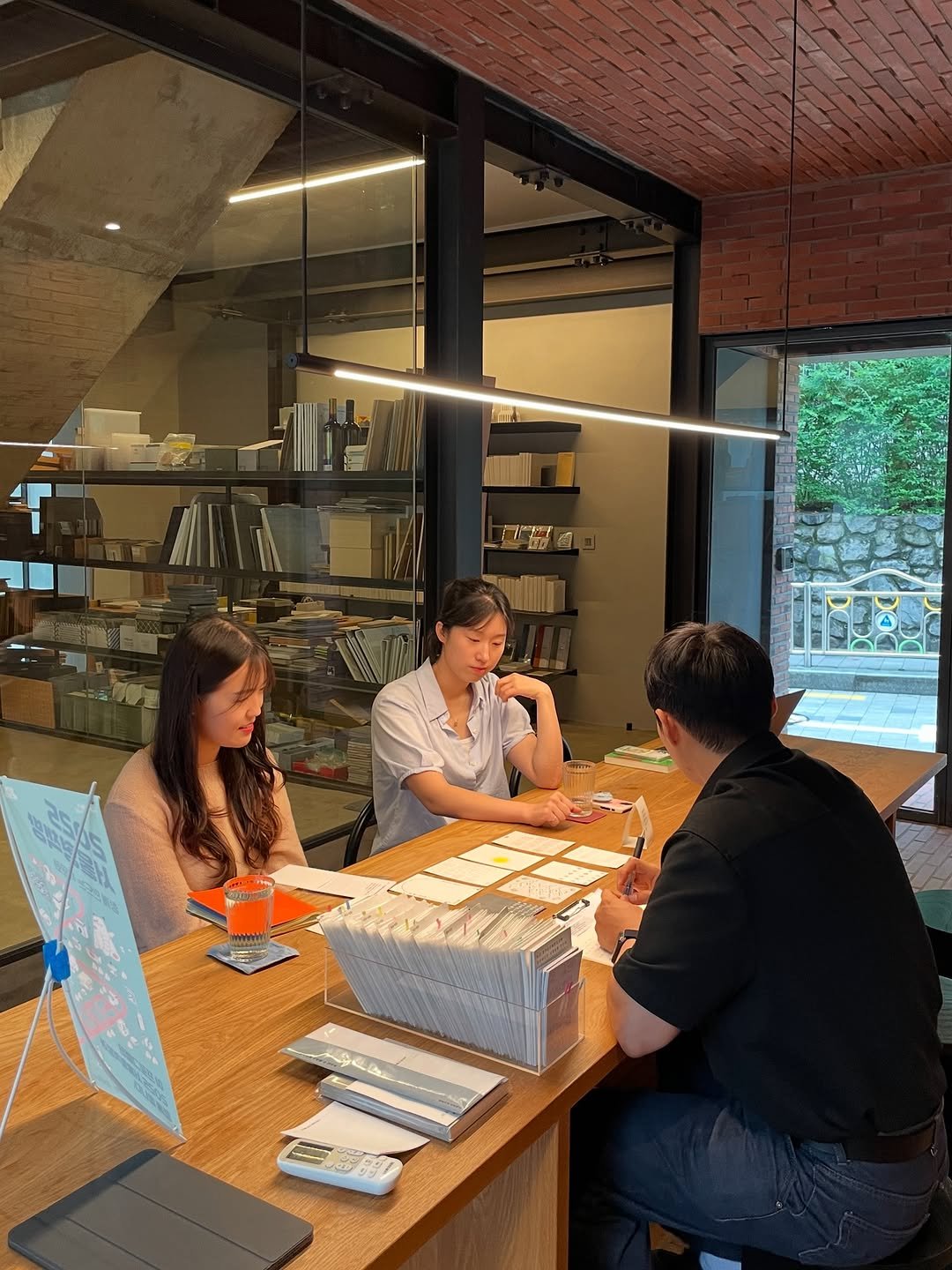 Photo by 인공위성 on August 14, 2025. May be an image of 3 people, people studying, lighting, table, bureau, desk, indoors, office and text.