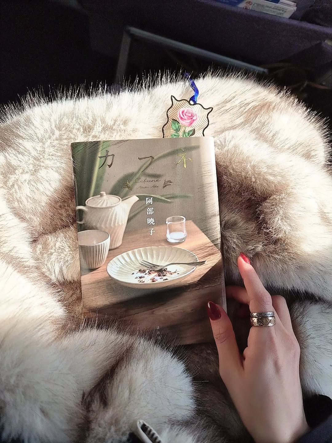 Photo by Sakura Miyawaki on January 08, 2026. May be an image of sable coat, book and tea.