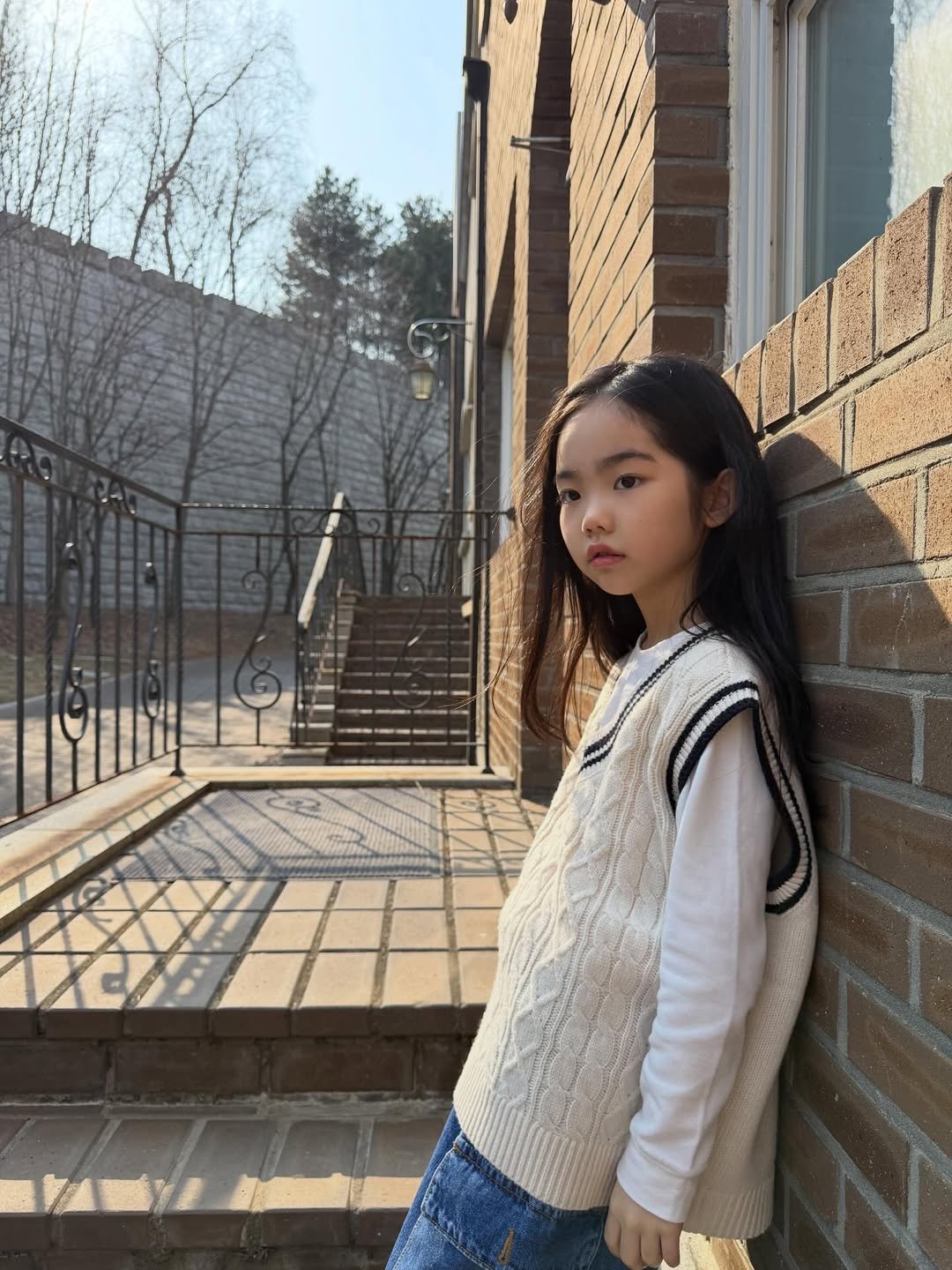 Photo by Hwang sumi_오은서 on March 30, 2026. May be an image of child, turtleneck, brick wall and text.