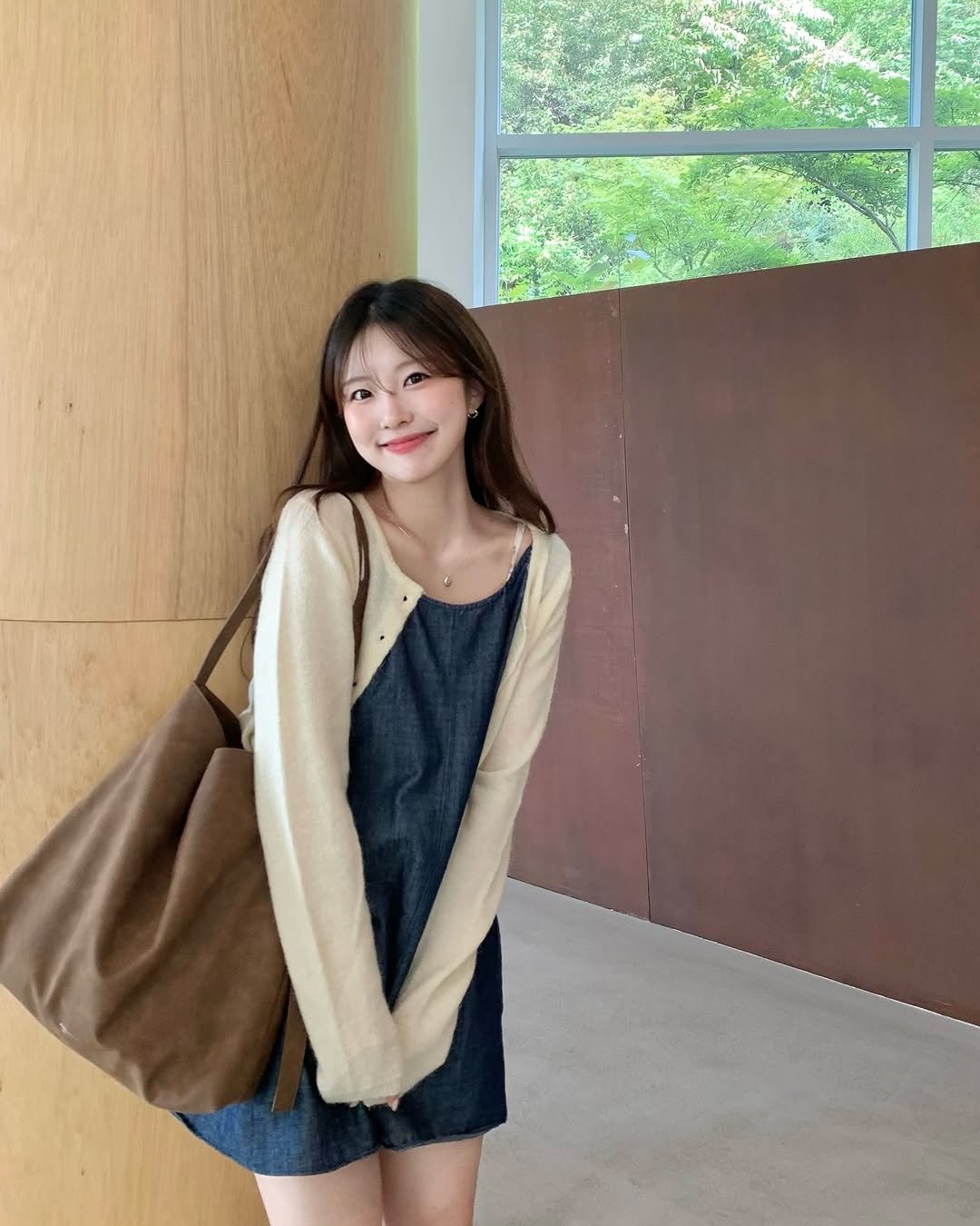 Photo by 나히 on September 14, 2025. May be an image of 1 person, duffle coat, cardigan, top, dress and text.