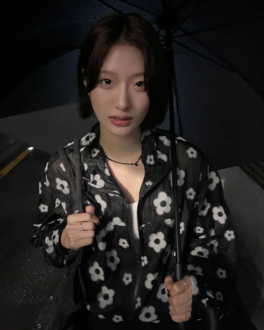 Photo by min on July 18, 2025. May be an image of 1 person, hair, raincoat, parka, parasol, umbrella and text.