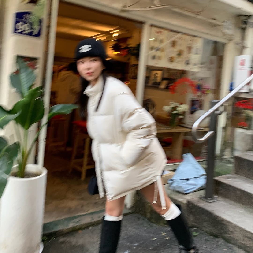 Photo by 이유빈 on October 25, 2025. May be an image of duffle coat, overcoat, goosedown coat, face mask, raincoat, parka, flight jacket, beret, street and text.