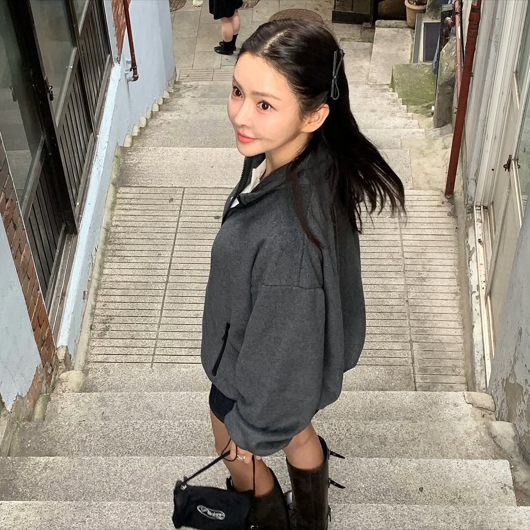 Photo by 이유빈 on October 23, 2025. May be an image of one or more people, hair, parka, boots, miniskirt and text.