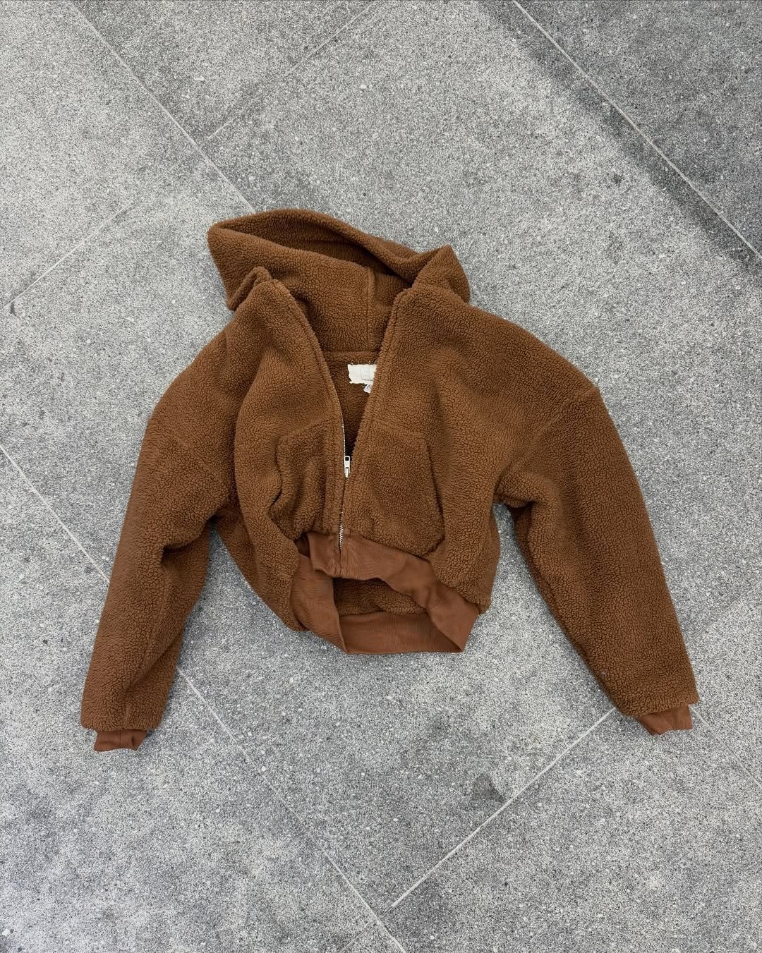 Photo shared by 8DIVISION on December 14, 2025 tagging @erl. May be an image of duffle coat, sherpa coat, fur coat, fleece, parka and text.