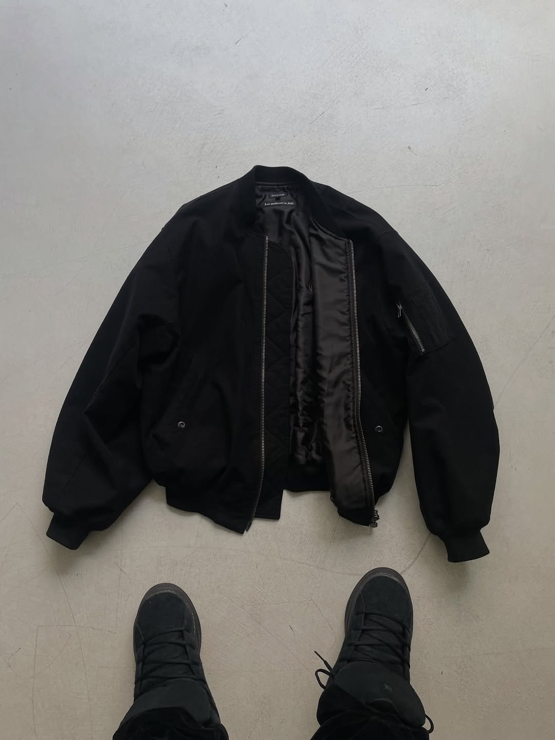 Photo shared by HEO SHINGU on December 16, 2025 tagging @8division, and @innirnet. May be an image of duffle coat, goosedown coat, flight jacket, parka and text.