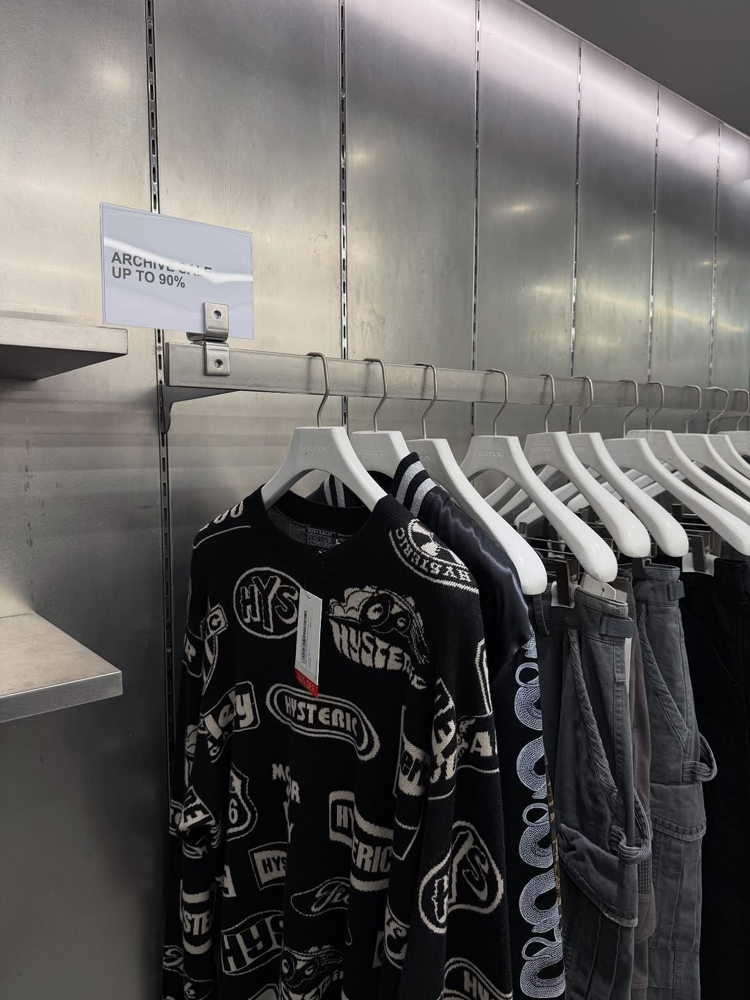 Photo by 8DIVISION on April 23, 2026. May be an image of clothes hanger, rack, sweatpants and text.