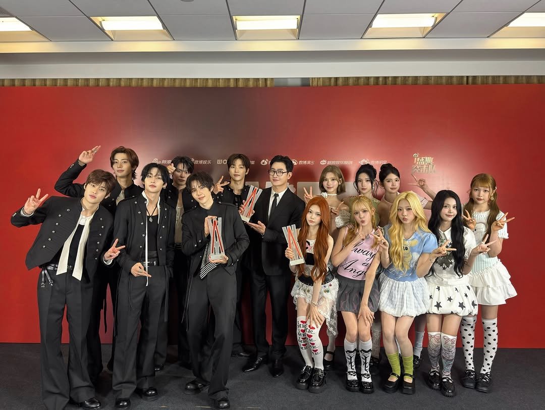 Photo shared by SM Entertainment Group on April 25, 2026 tagging @zhouzhoumi419, @riize_official, and @hearts2hearts. May be an image of costume, dinner jacket and text.