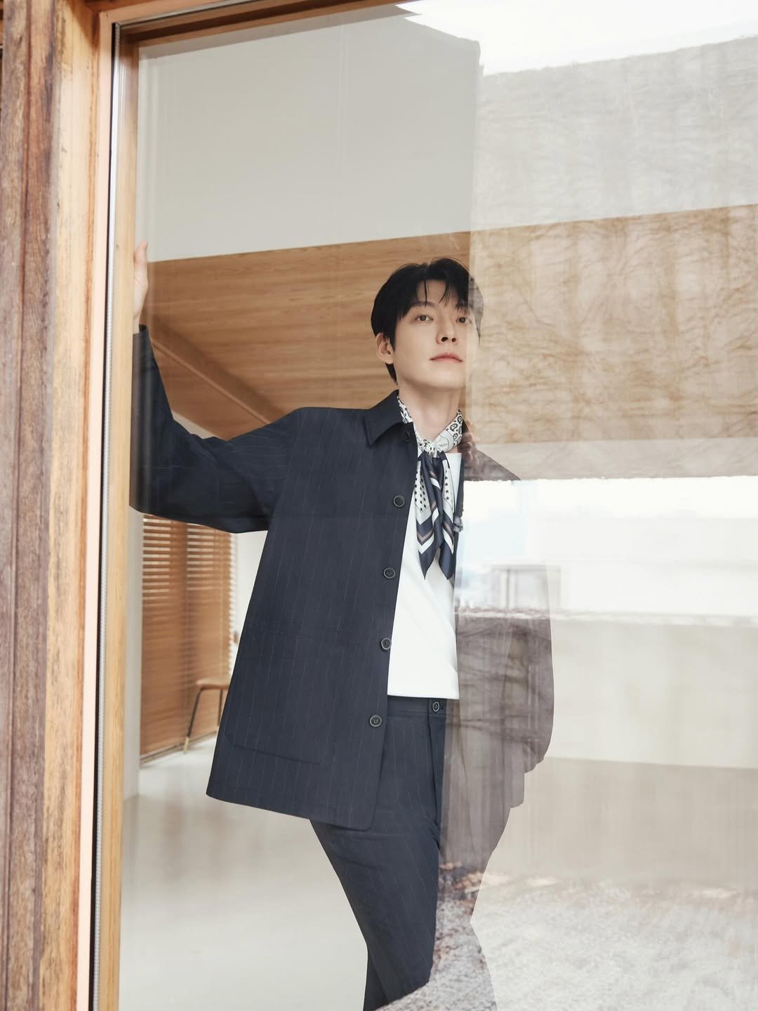 Photo by 김우빈 on March 12, 2026. May be an image of duffle coat, overcoat, suit, bolo tie, top and text.