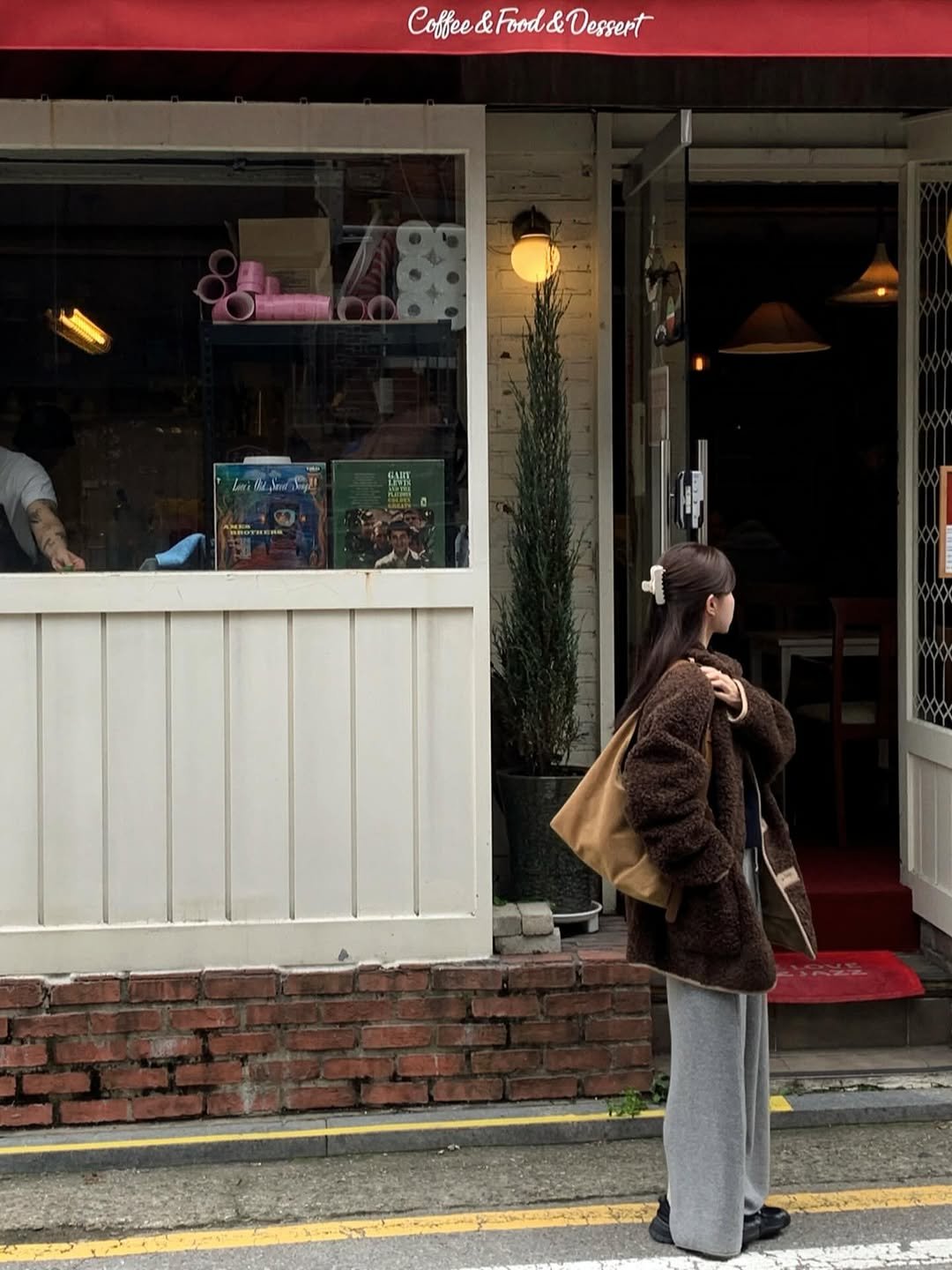 Photo shared by 알로하 on October 18, 2025 tagging @anoetic_kr. May be an image of duffle coat, overcoat, parka, street and text.