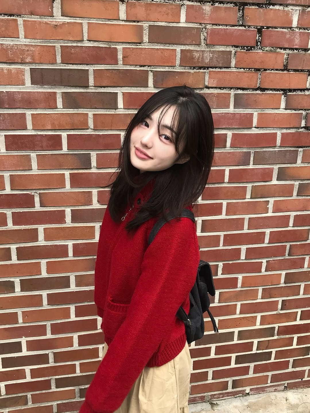 Photo by 소이 on October 21, 2025. May be an image of duffle coat, sweater, turtleneck, knit, brick wall and text.