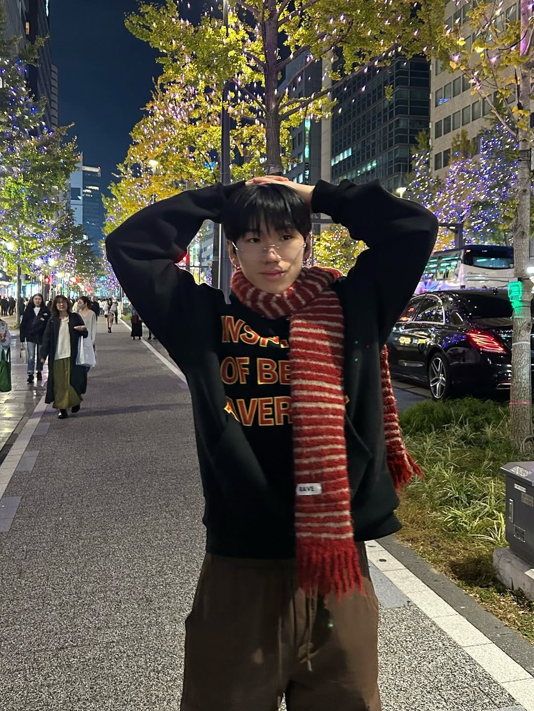 Photo by 김용빈 / 유포어 on December 11, 2025. May be an image of duffle coat, bandanna, street, night and text.