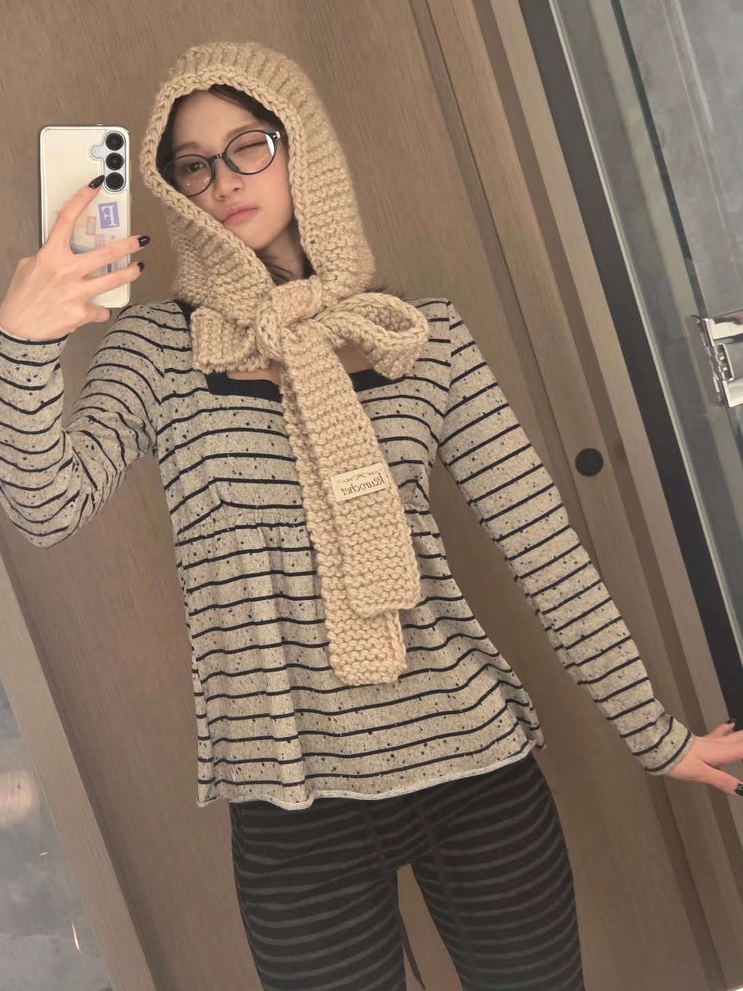 Photo shared by 김채원 (CHAEWON) on December 01, 2025 tagging @39saku_chan. May be a selfie of cardigan, stripes, scarf, knit, headscarf, sweater and text.