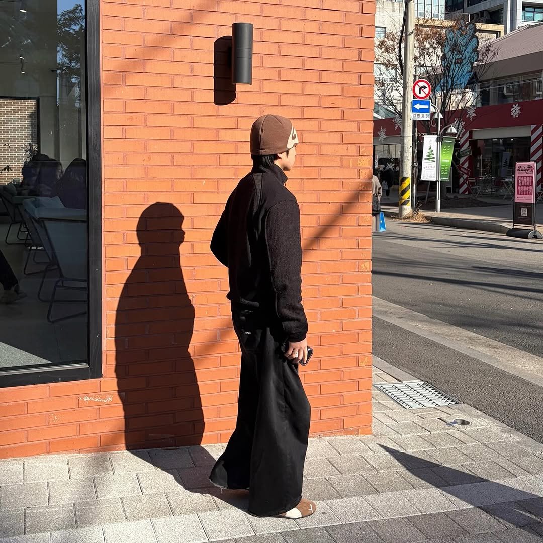 Photo shared by 동규 | 패션 크리에이터 on December 28, 2025 tagging @puma, @folder_korea, and @puma_kr. May be an image of standing, overcoat, duffle coat, face mask, street and text.