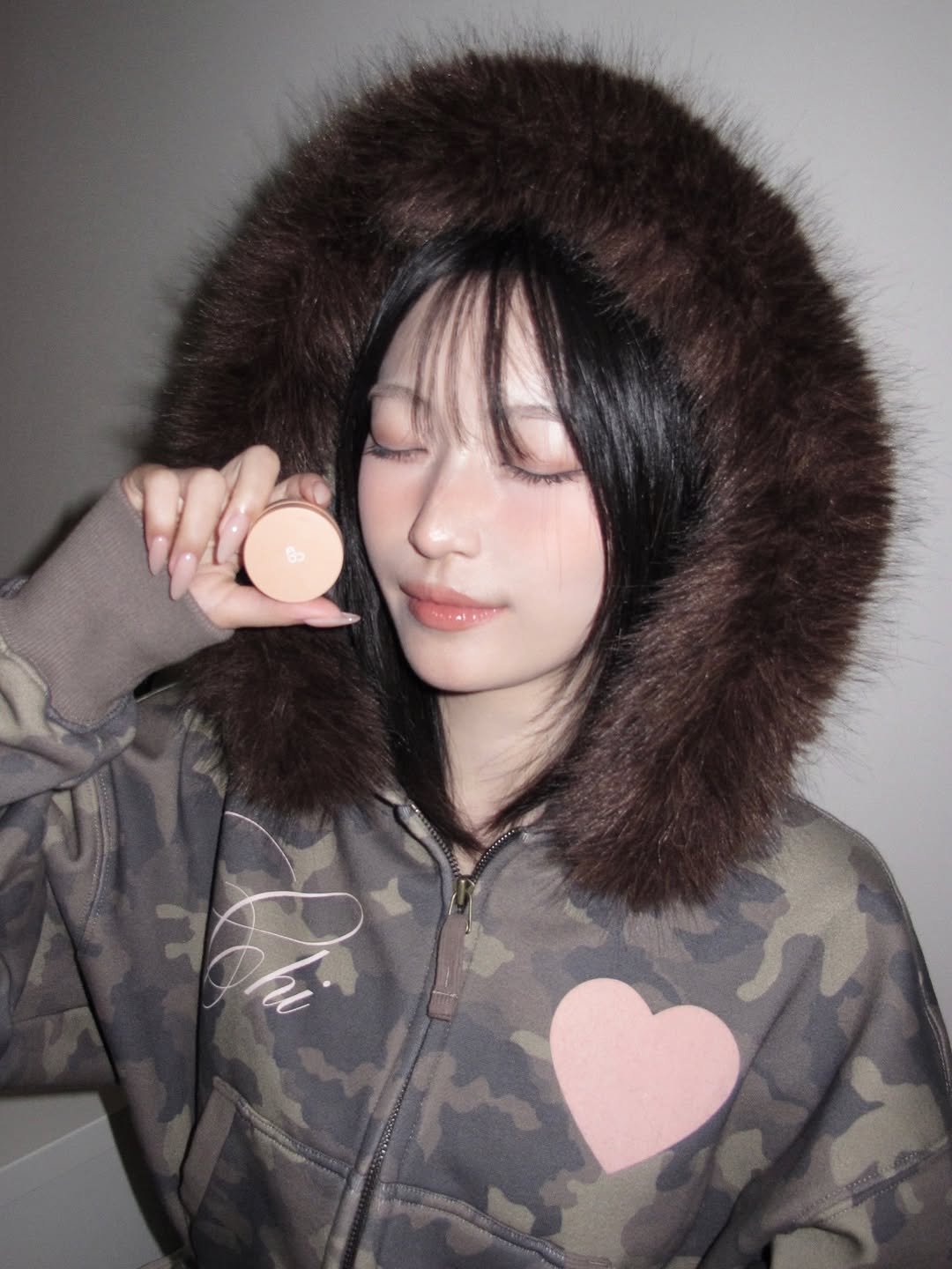 Photo shared by 김은솔 on December 26, 2025 tagging @hemeko.o, and @aoucosmetics. May be an image of one or more people, lipstick, makeup, fur coat, goosedown coat, duffle coat, parka, jacket, military uniform and text.