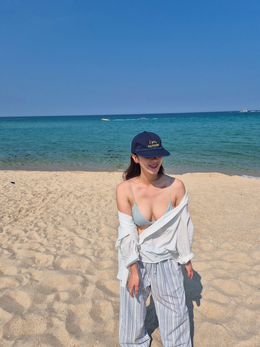 Photo by 🦦 on August 25, 2025. May be an image of 1 person, hat, sarong, ocean, beach and text.