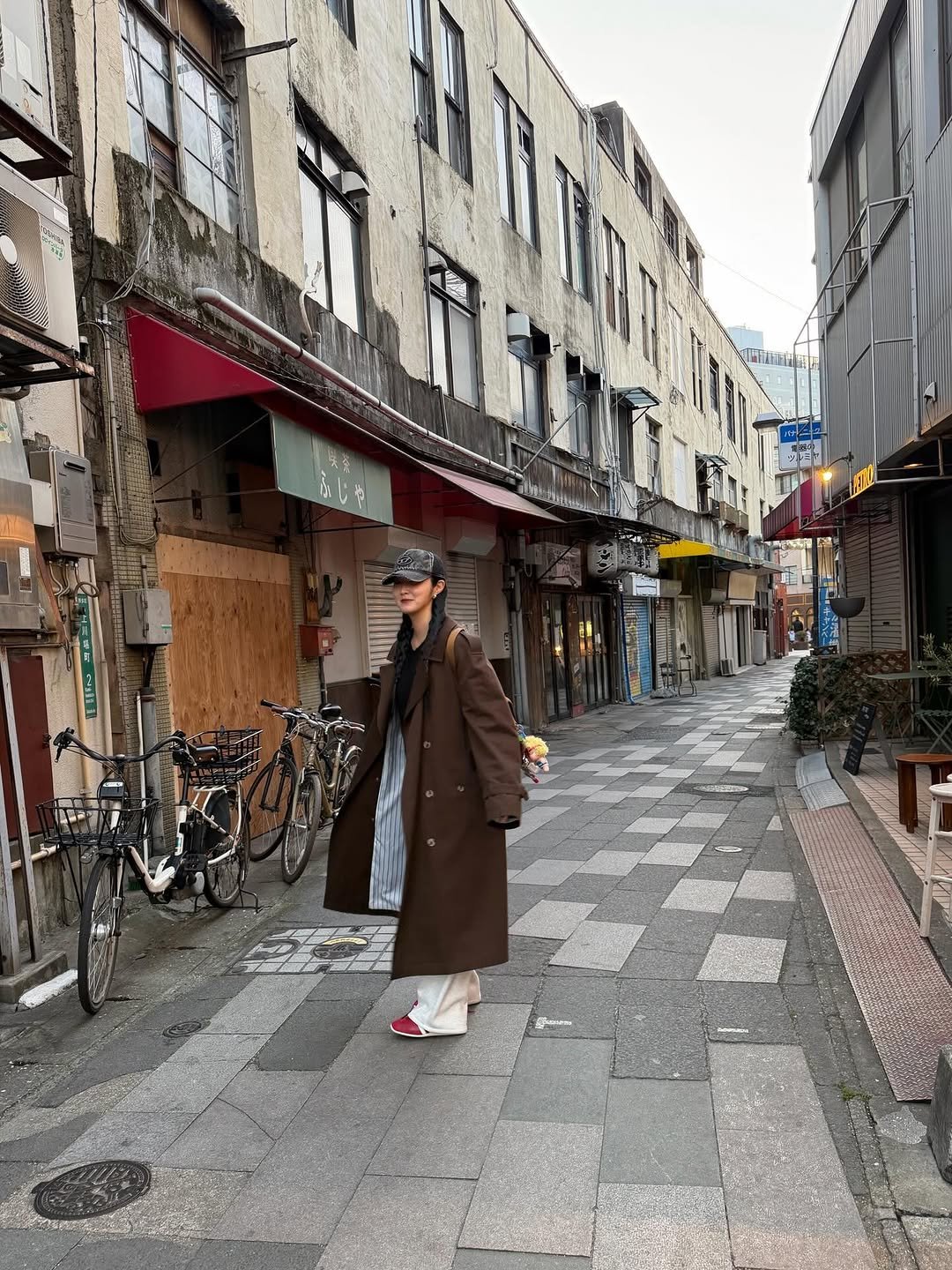 Photo shared by 이주은 on February 01, 2026 tagging @afterpray_official. May be an image of one or more people, overcoat, duffle coat, bath robe, street and text.