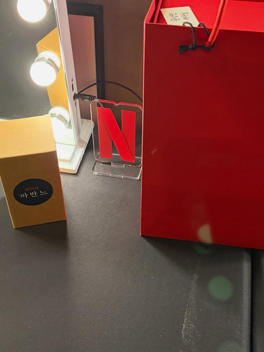 Photo shared by 문상민 on February 13, 2026 tagging @plusm_entertainment, and @netflixkr. May be an image of one or more people, lipstick, makeup, fragrance, box, perfume, hand cream and text.