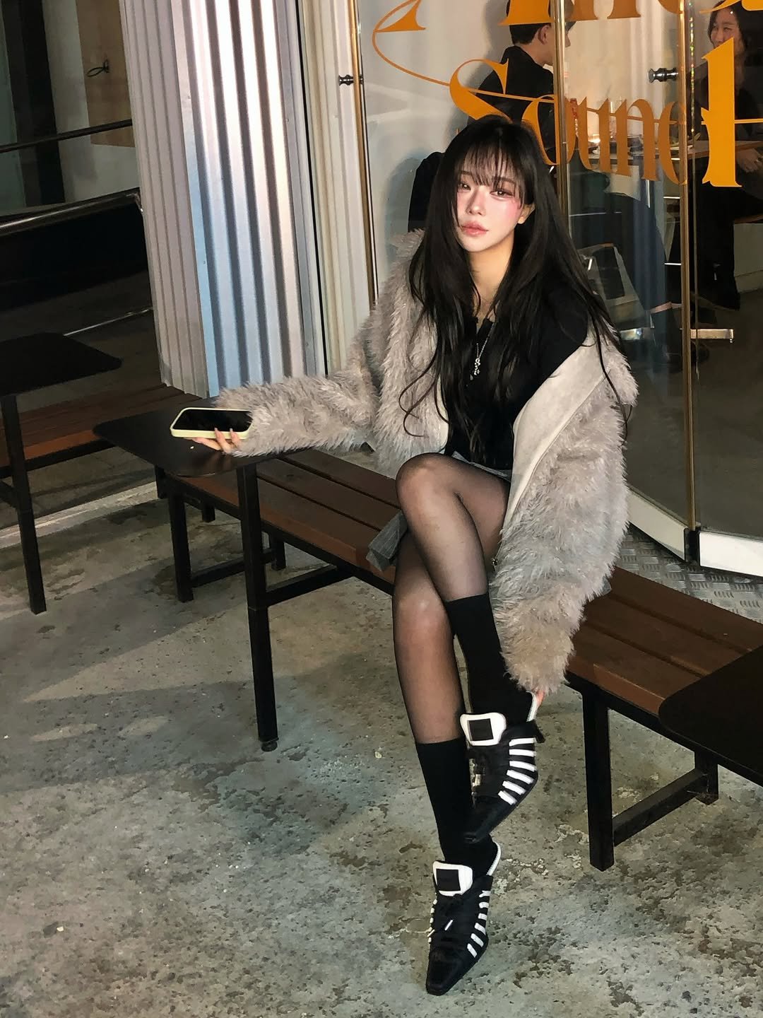 Photo shared by 임서현 on November 24, 2025 tagging @yelloshoes_official. May be an image of one or more people, hair, duffle coat, overcoat, fur coat, parka, tights, fishnet stockings and text.