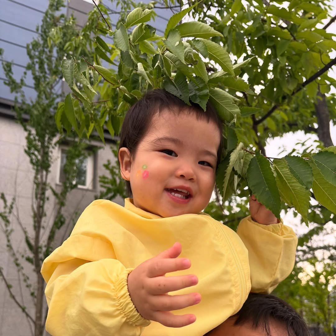 Photo by ʚ♡ɞ 채아네 ʚ♡ɞ on June 23, 2025. May be an image of 1 person, baby, raincoat, tree, outdoors and text.