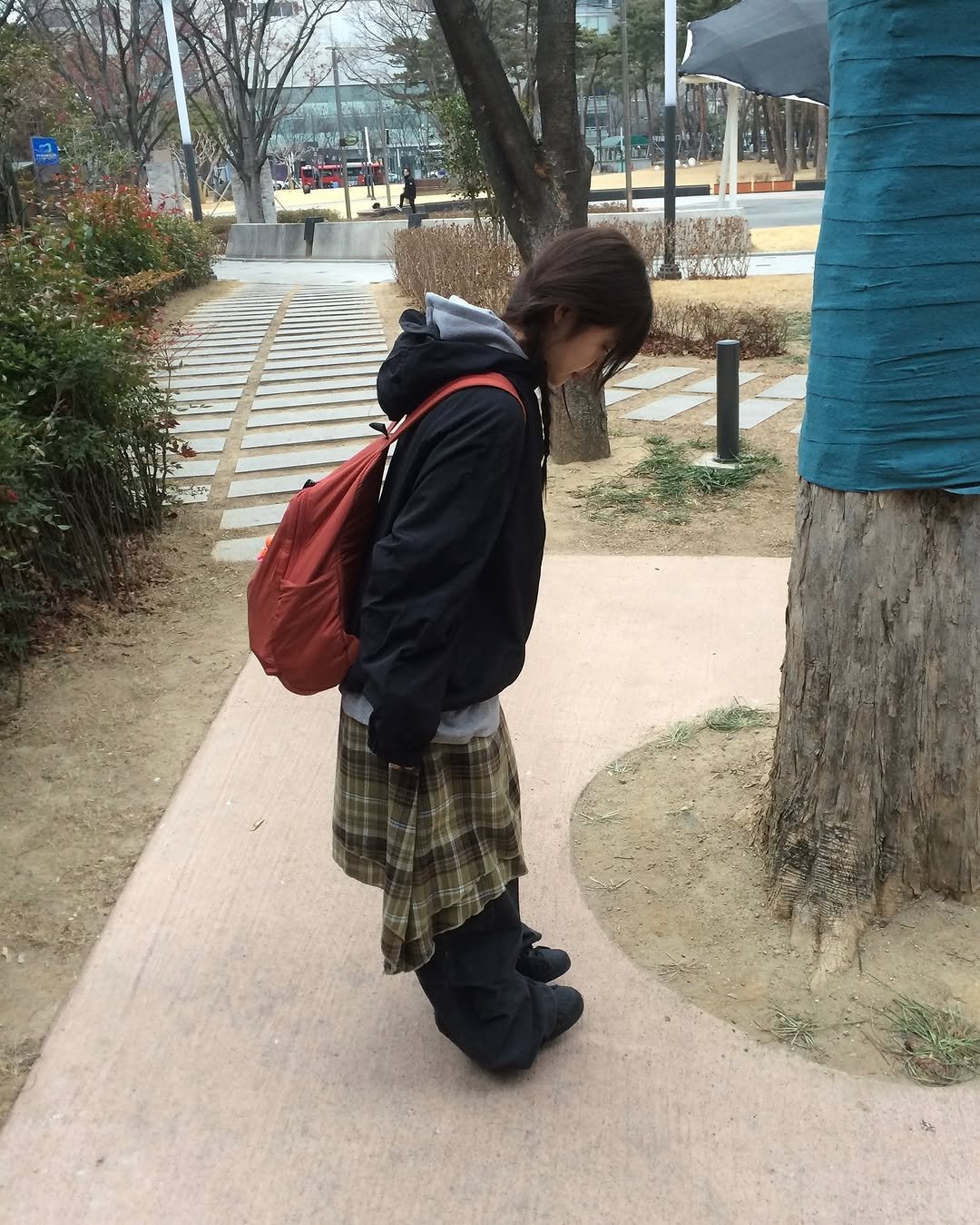 Photo by 예잇 on February 13, 2026. May be an image of standing, kilt, miniskirt, park and text.