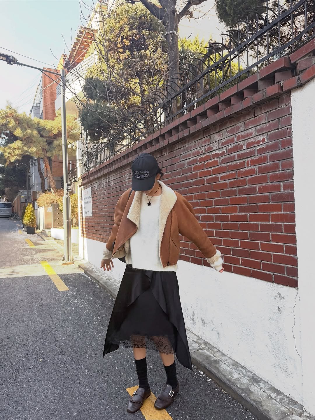 Photo by 안유진 AN YUJIN on January 30, 2026. May be an image of duffle coat, overcoat, parka, kilt, cloak, beret, face mask, street and text.