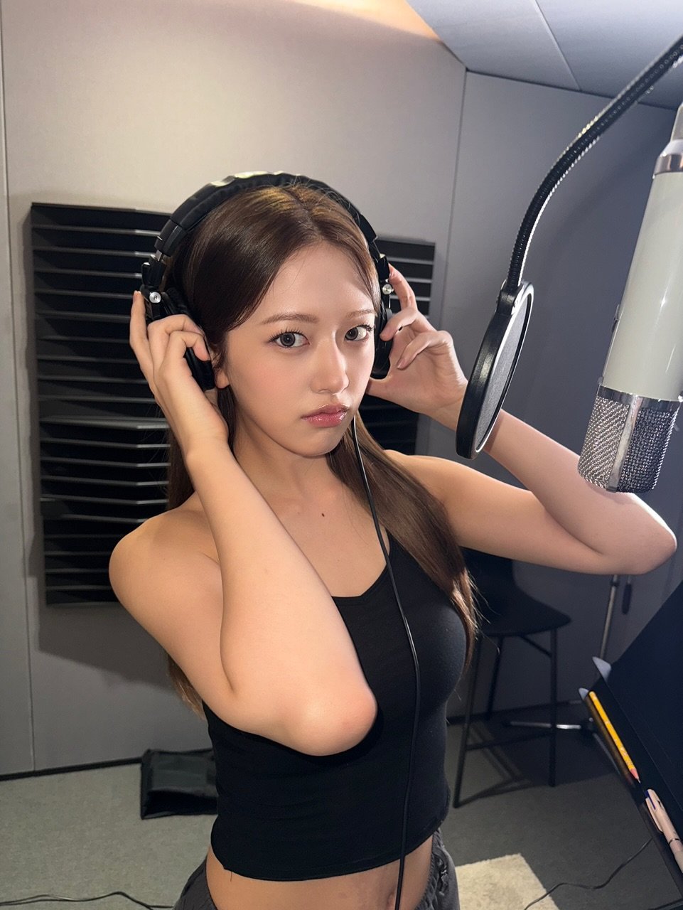 Photo by 안유진 AN YUJIN on July 19, 2025. May be an image of 1 person, hair, top, microphone and text.