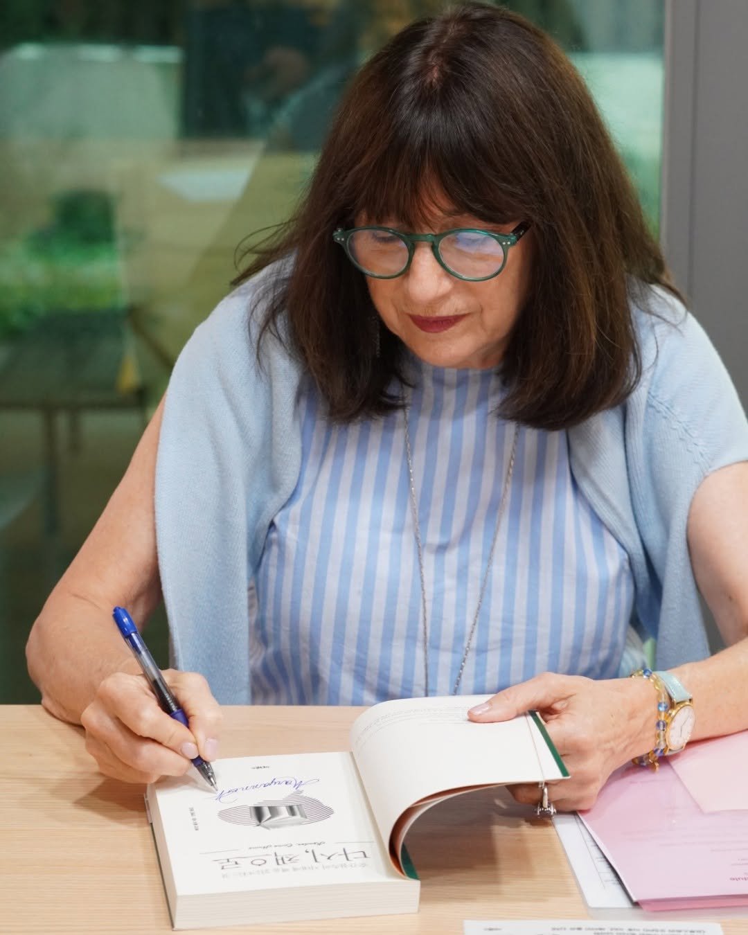 Photo shared by 어크로스 on September 29, 2025 tagging @_maryanne_wolf_. May be an image of 1 person, studying, eyeglasses, book, pen, magazine and text.
