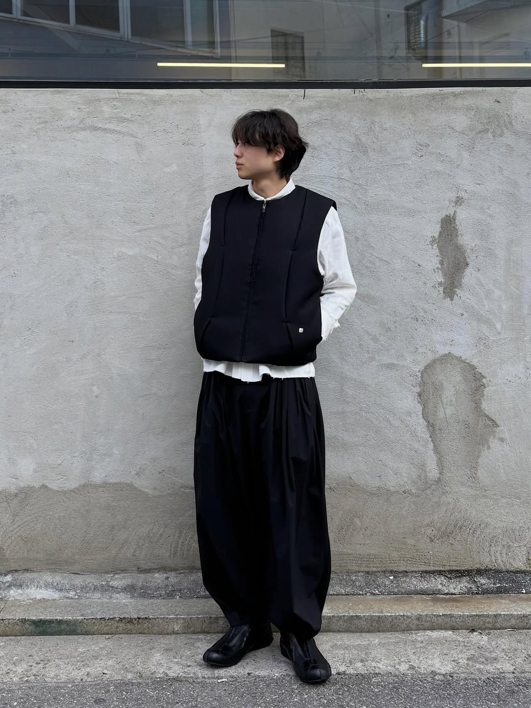 Photo by ADERERROR SPACE on December 07, 2025. May be an image of duffle coat, parka, sweatpants and text.