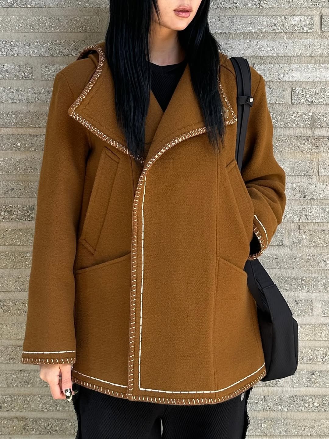 Photo by ADERERROR SPACE on November 02, 2025. May be an image of duffle coat, overcoat, cardigan, parka, fleece, jacket, wool and text.