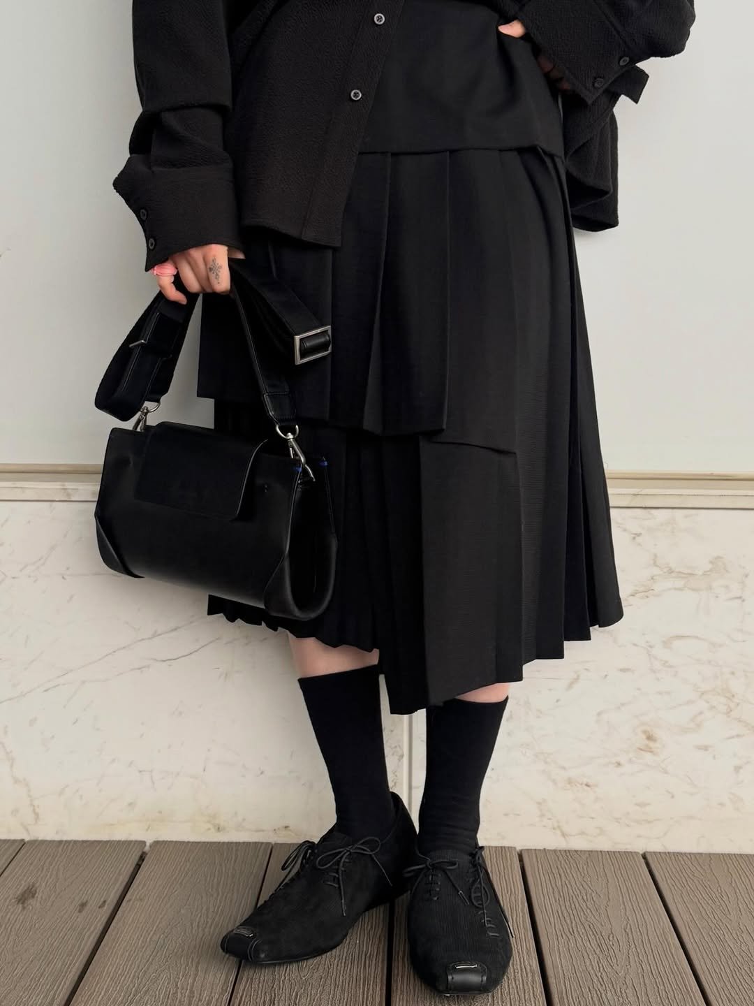 Photo by ADERERROR SPACE on February 17, 2026. May be an image of overcoat, kilt and text.