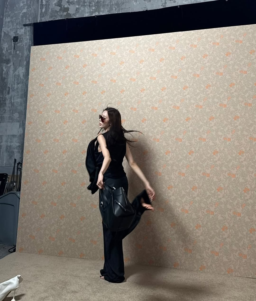 Photo shared by GISELLE on November 15, 2025 tagging @loewe. May be an image of standing, curtains, carpet and text.