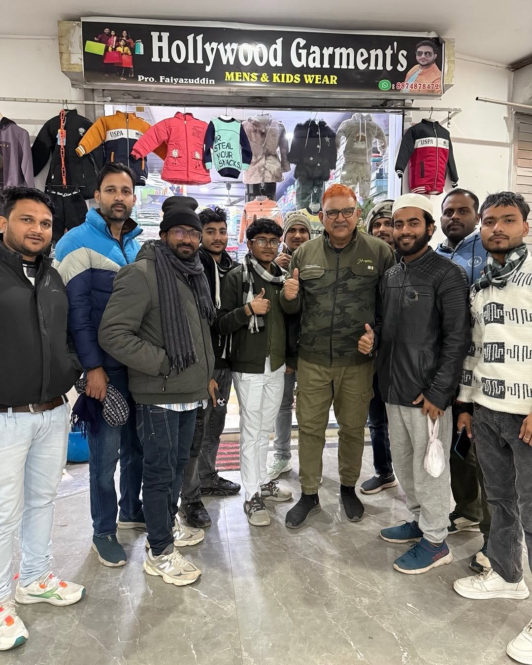 Photo by Afaq Khan on December 31, 2025. May be an image of one or more people, people standing and text that says 'Hollywood HollywoodGarment's Holly Garment's Pro. Faiyazuddin MENS & KIDS WEAR W © ©:8874879172 USPA ETEAL YOUR CUR SMCKS 版 บรอจ াम।।-) ወበጣባቤ Ir JR അഹിവ ग சவா រូល បរុមី'.