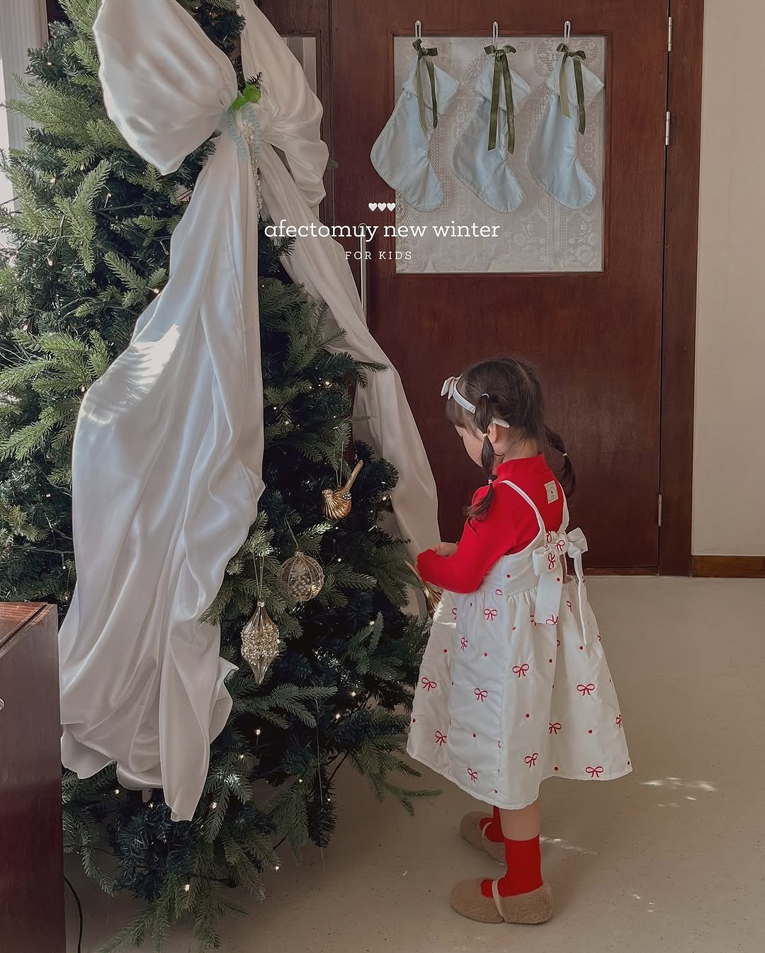 Photo by 아펙토무이 on November 11, 2025. May be an image of child, christmas tree, Christmas stocking, tinsel, dress and text.
