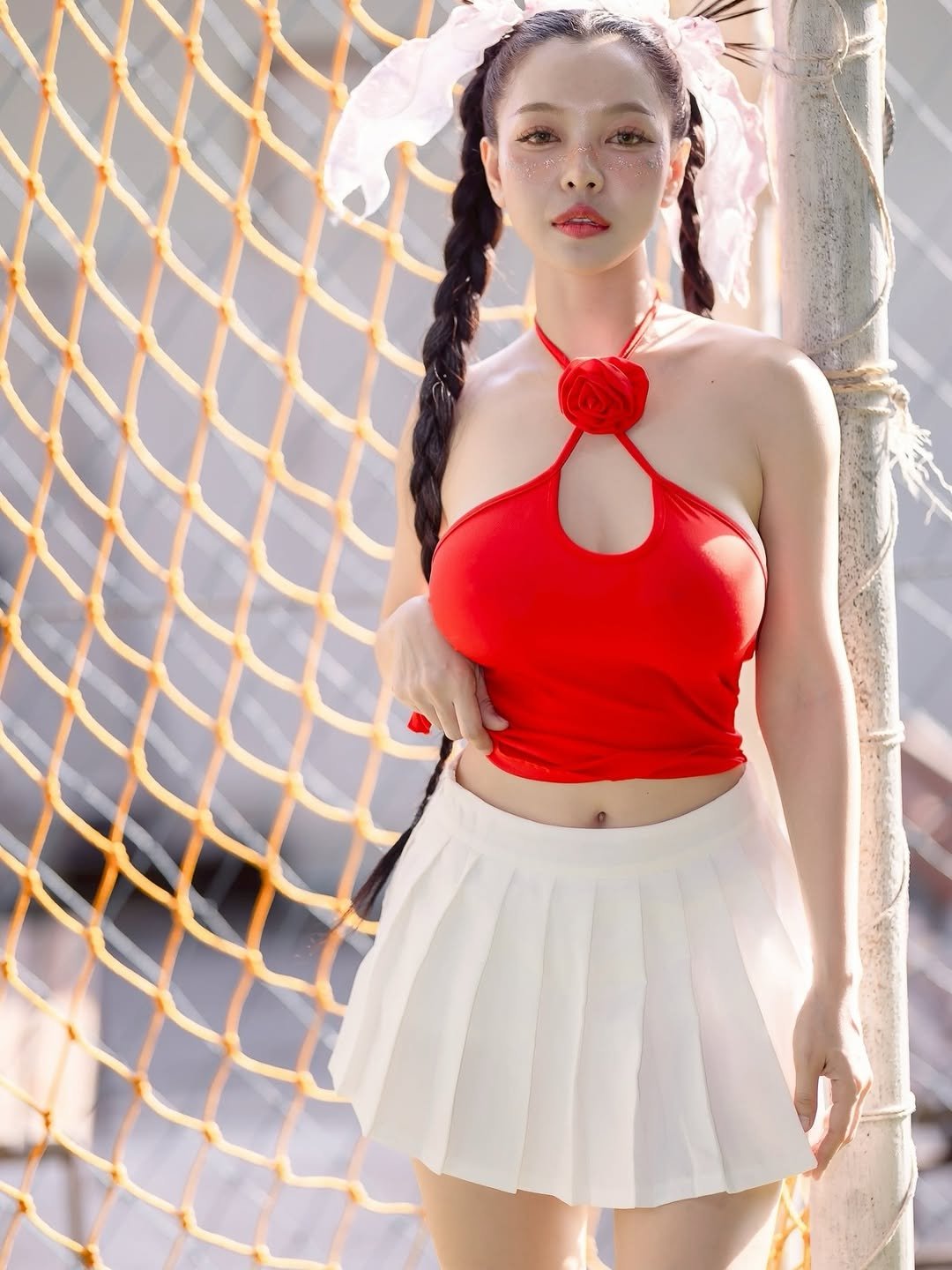 Photo by ไอเนะ ยูคิมุระ on February 10, 2026. May be an image of one or more people, braids, fishnet stockings, miniskirt, bra and text.