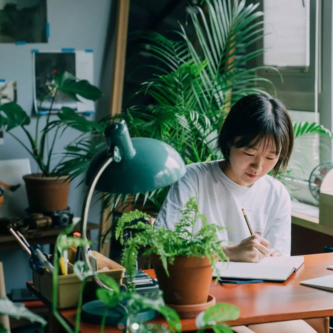 Photo by 융 Ashley on August 17, 2025. May be an image of 1 person, studying, desk, bureau, house plant, plant, office and text.