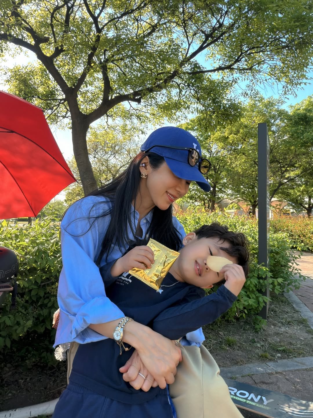 Photo by 김 아린 아린뷰 (alyn_view) on April 26, 2026. May be an image of baby, sling, umbrella and text.