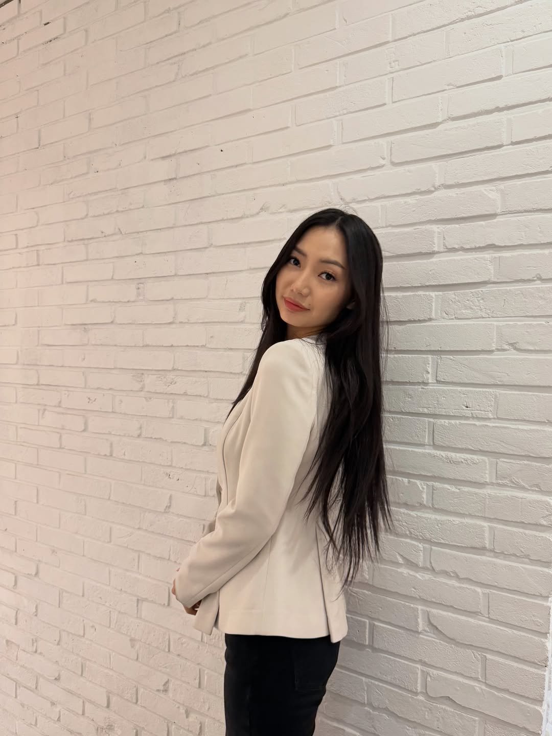 Photo shared by Anu Ujin on December 21, 2025 tagging @1mm.mongolia. May be an image of one or more people, hair, jacket, suit, blazer, brick wall and text.