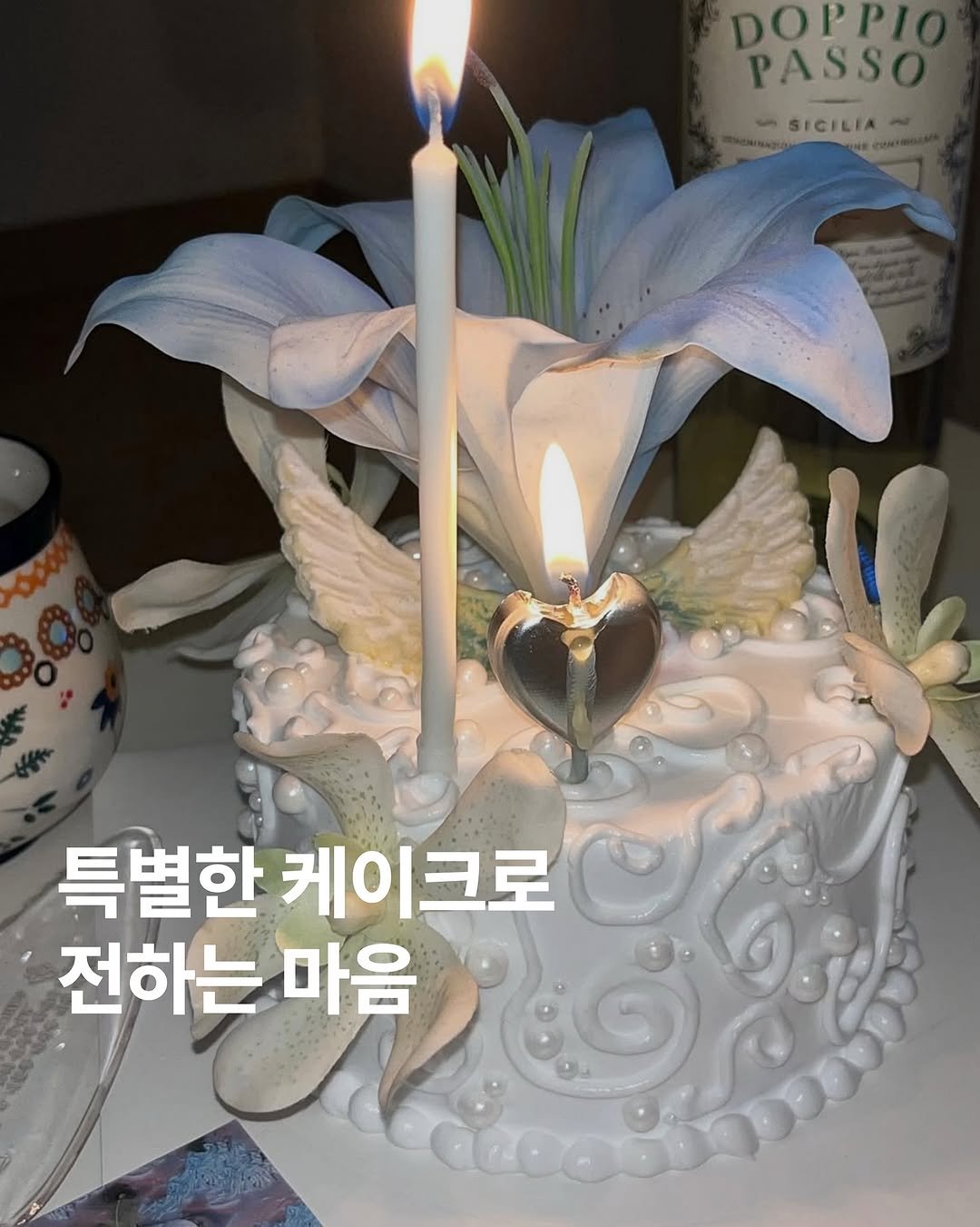 Photo by 아카이브홈 | 패션•트렌드 매거진 on August 12, 2025. May be an image of cake, candle, white lily, lily and text that says 'DOPPI PASSO dn SICILIA- Mcomm 특별한 케이크로 전하는 마음'.