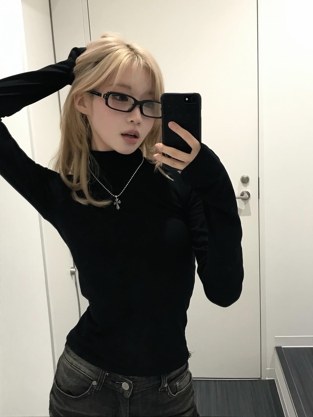 Photo shared by BABYMONSTER ASA (아사) FANPAGE on December 31, 2025 tagging @babymonster_ygofficial, and @babymonster_ygs. May be a selfie of one or more people, blonde hair, eyeglasses, turtleneck, mirror and text.