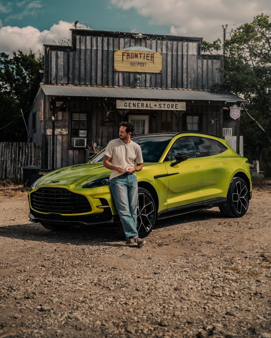 Photo shared by Aston Martin on February 20, 2026 tagging @lifeof_riley. May be an image of race car, blower, road and text that says 'FRONTIER OUTPO5T GENERAL*: ENERAL*STORE *STORE'.