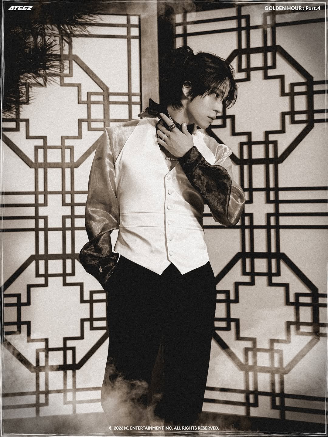 Photo shared by ATEEZ(에이티즈) on January 13, 2026 tagging @yunou._.u. May be a black-and-white image of overcoat, suit, barong, cigarette, dinner jacket, bolo tie, blazer and text.