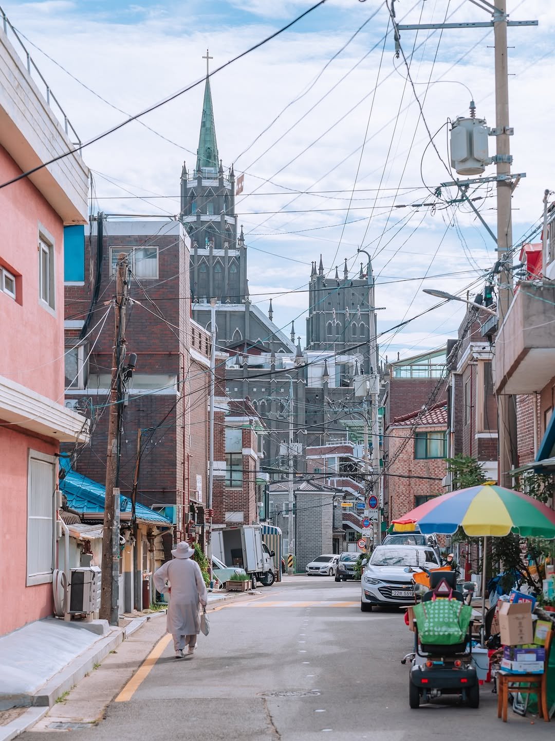 Photo shared by 빈백 | CHANG SU, OH on September 25, 2025 tagging @suwon_city. May be an image of 3 people, umbrella, street, buildings, telephone pole and text.