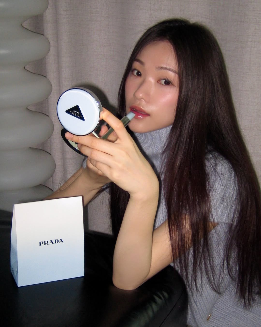 Photo shared by 🪞윤경 | 패션모델 on February 05, 2026 tagging @pradabeauty. May be an image of one or more people, makeup, phone, camera, portable cassette player and text that says 'D PRADA PRADA'.